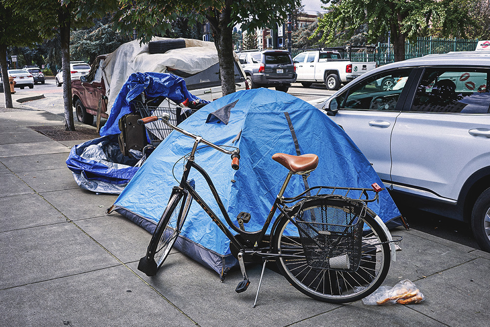 Portland, OR, USA - Homeless tent and belongings on the sidewalk in downtown Portland.